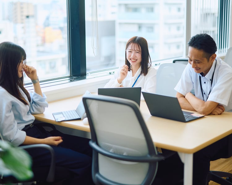 社内ミーティングで笑顔を見せる社員たち